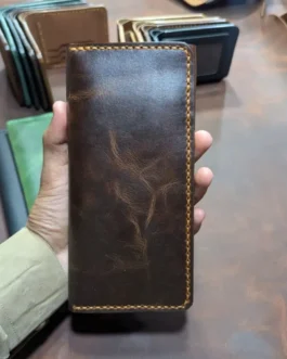 Handcrafted brown genuine leather mobile long wallet with yellow contrast edge stitching held in hand