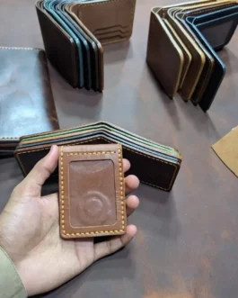 Front view of a handcrafted brown magnetic leather ID card holder with clear badge window and yellow stitching.